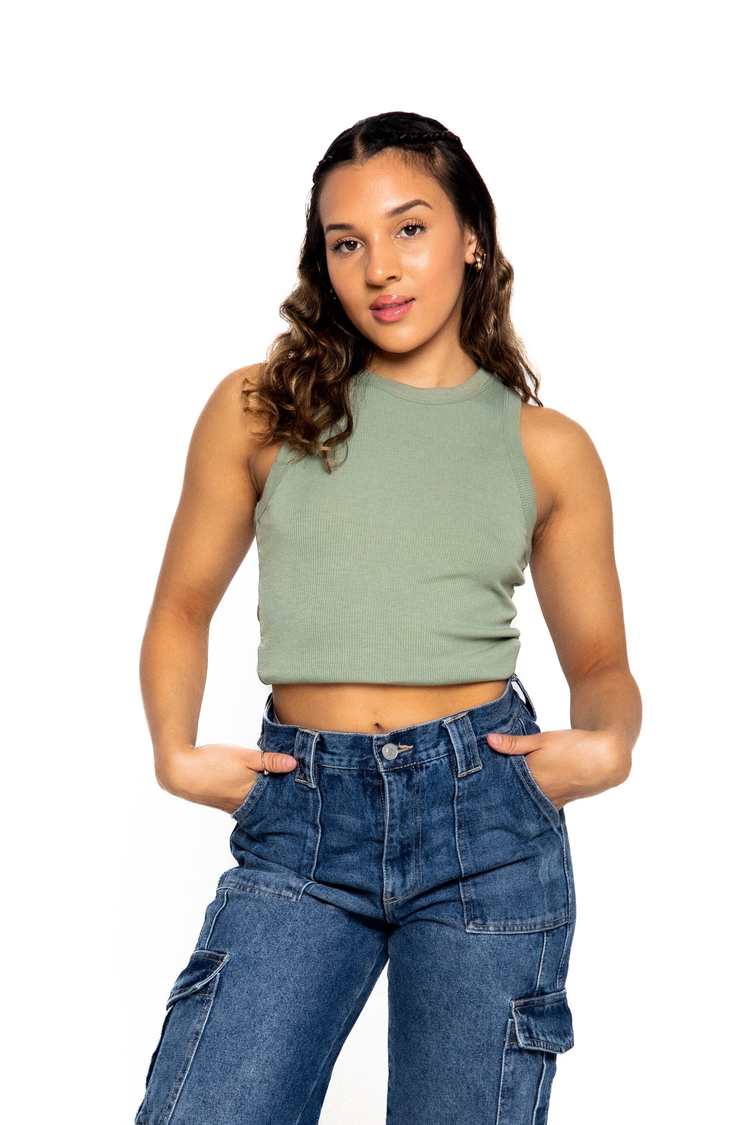 A fashionable women wearing green crop top and denim jeans